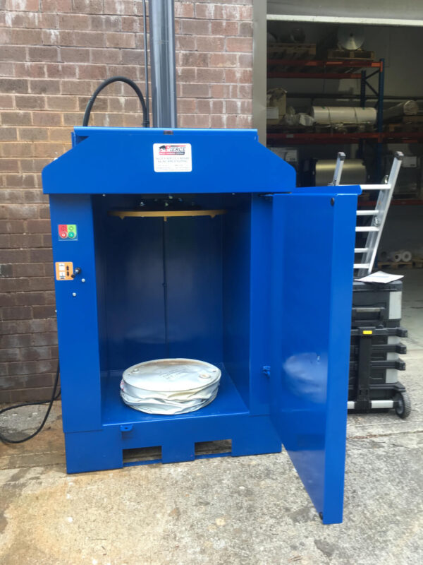 drum crusher in blue with a crushed drum beneath