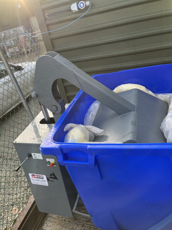 Wheelie bin compactor in operation