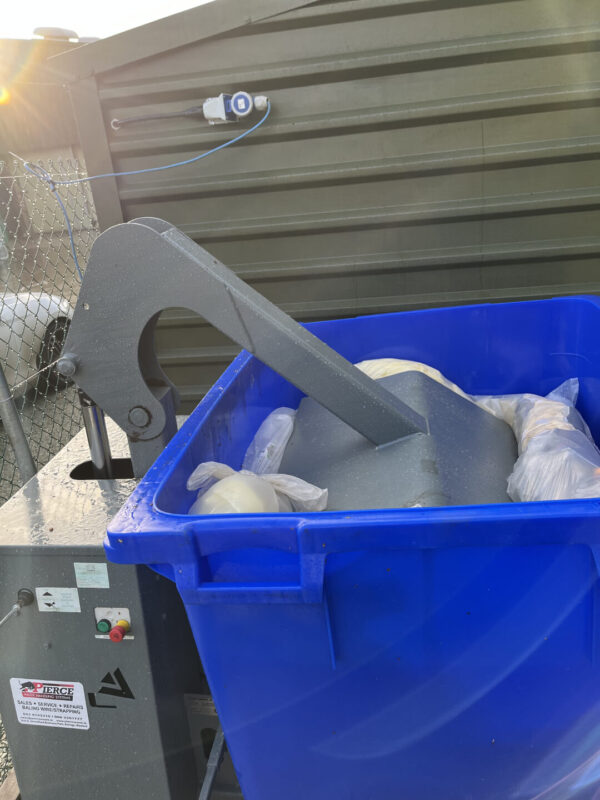 Wheelie bin compactor in operation
